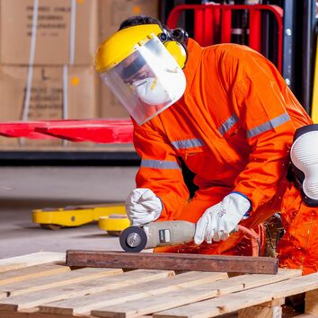 Mann beim Flexen von Metall hockend