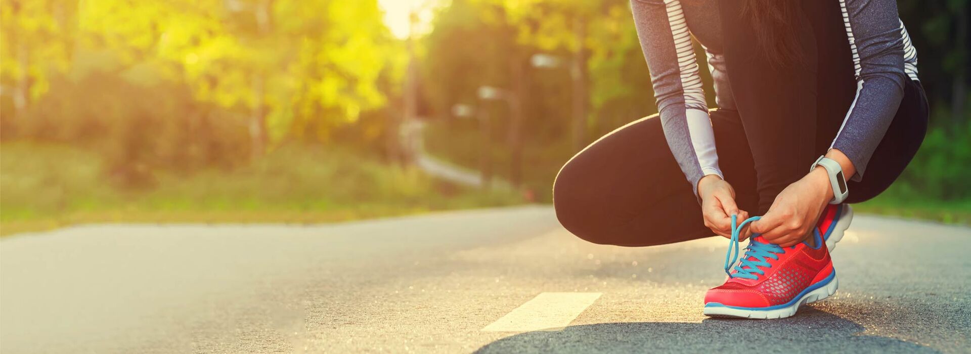 Frau bindet sich Laufschuh zu