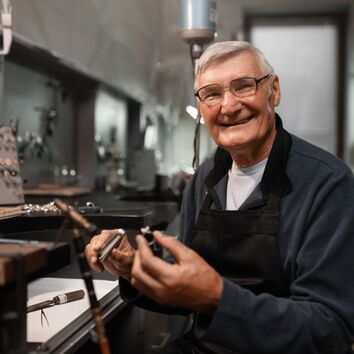 älterer Mitarbeiter im Juweliergeschäft bei der Arbeit