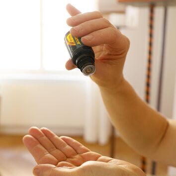 Frau tropft Öl auf ihre Linke Hand